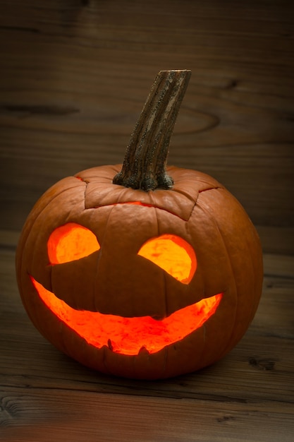 Smiling lantern pumpkin on a wooden background