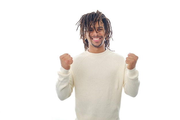 Smiling latin man celebrating victory and success while standing on an isolated background. Success and achievement concept.