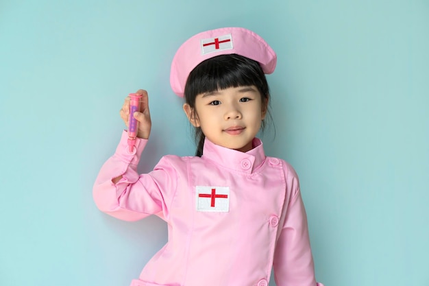 Smiling little asian girl wearing a doctor's coat posing and looking at camera Child future doctor