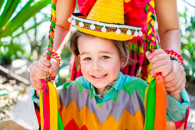 Smiling little boy holding his mother braids.