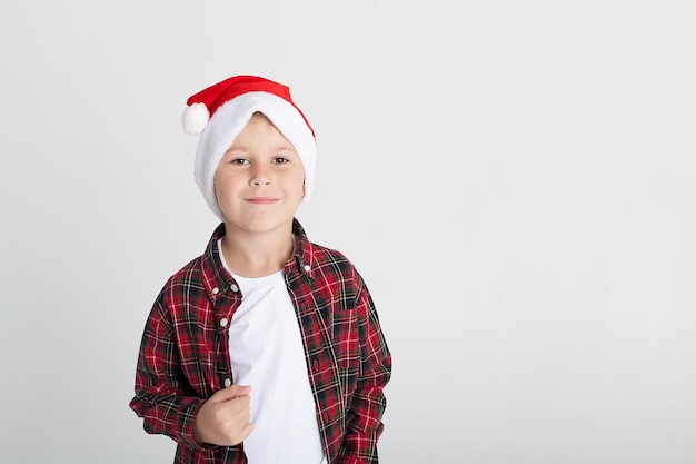 Smiling little boy in Santa's hat with gift box isolated on white