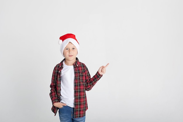 Smiling little boy in Santa's hat with gift box isolated on white