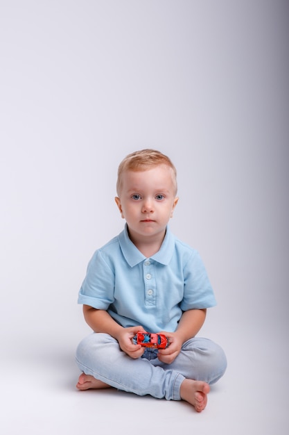 Smiling little boy sitting with toy