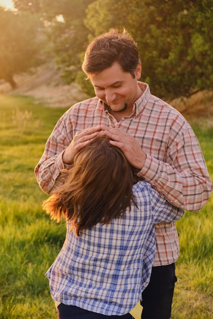 Smiling little girl hugging her father outside