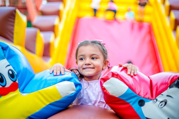 smiling little girl is playing in the park She has fun on carousel