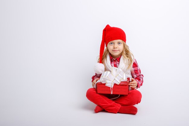 smiling little girl in Santa hat with gift box isolated on white background