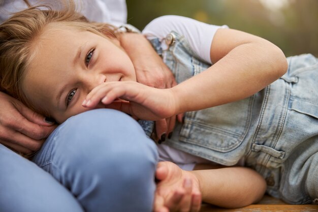 Smiling little girl spending time in the outdoors while posing at the photo camera