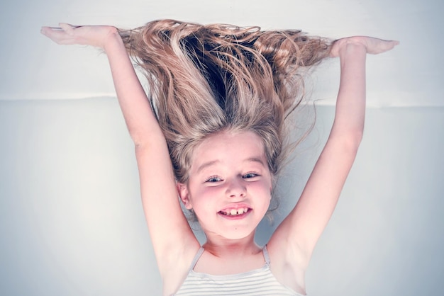 Smiling little girl stands on her hands