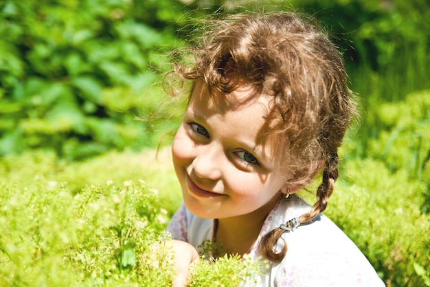 Smiling little girl with green grass outdoors