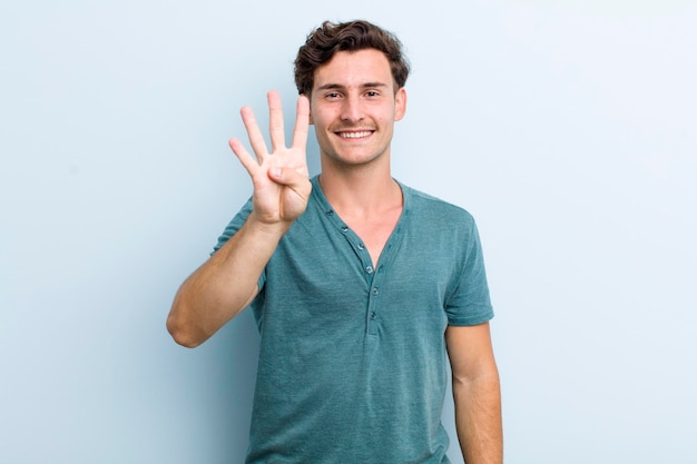 Smiling and looking friendly showing number four or fourth with hand forward counting down