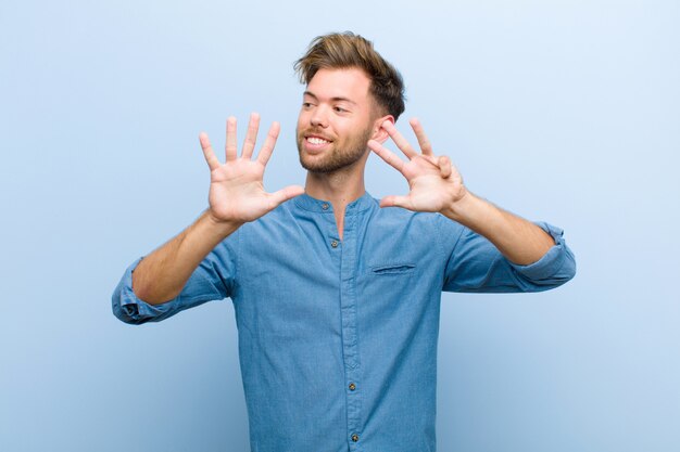 smiling and looking friendly, showing number nine or ninth with hand forward, counting down