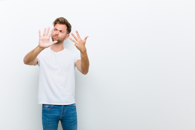 smiling and looking friendly, showing number nine or ninth with hand forward, counting down