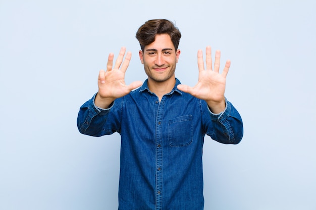 smiling and looking friendly, showing number nine or ninth with hand forward