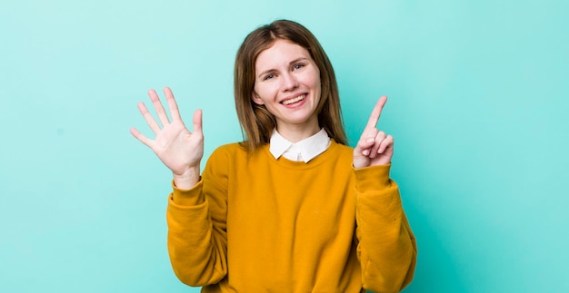 Smiling and looking friendly showing number six or sixth with hand forward counting down