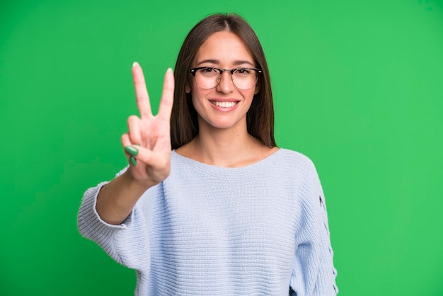 Smiling and looking friendly showing number two or second with hand forward counting down