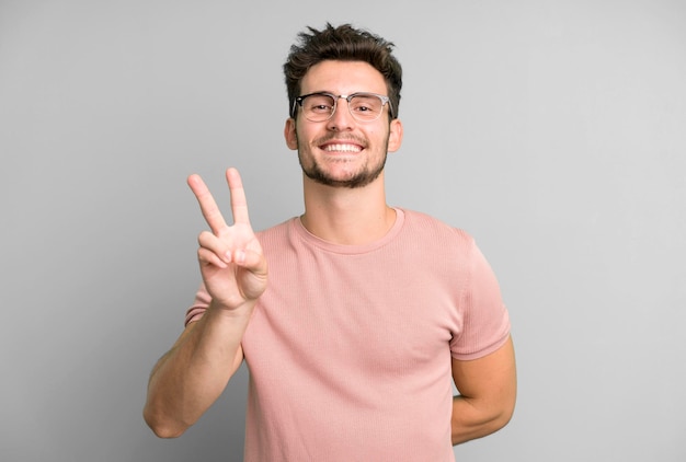 Smiling and looking happy carefree and positive gesturing victory or peace with one hand