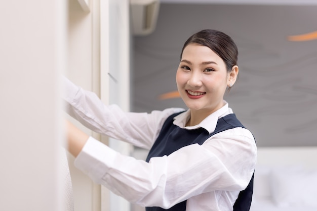 Smiling maid with White bathrobe with hanger in wardrobe, The concept of the hotel business