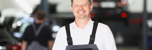 Smiling maintenance center worker in uniform man fill in papers on car checkup