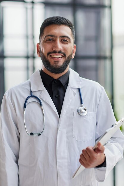 Smiling male doctor with arms crossed in hospital