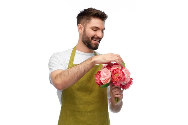 Photo smiling male gardener with bunch of peony flowers