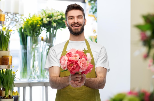 smiling male seller with bunch of peony flowers