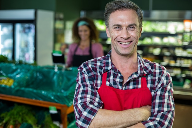 Photo smiling male staff standing with arms crossed in organic section