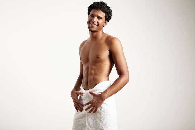 Smiling man after shower wears white towel