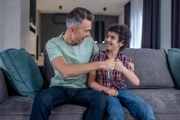 Smiling man and boy touching with fists