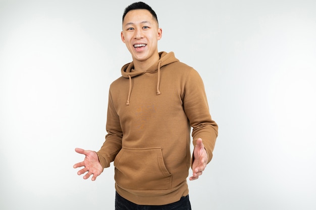 Smiling man in brown hoodie with open arms on a white