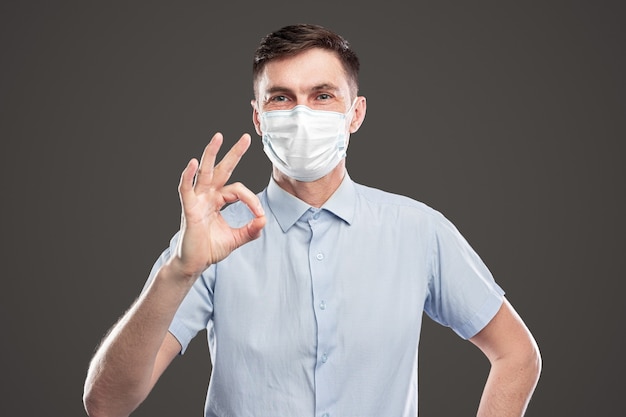 Smiling man in face mask showing ok gesture