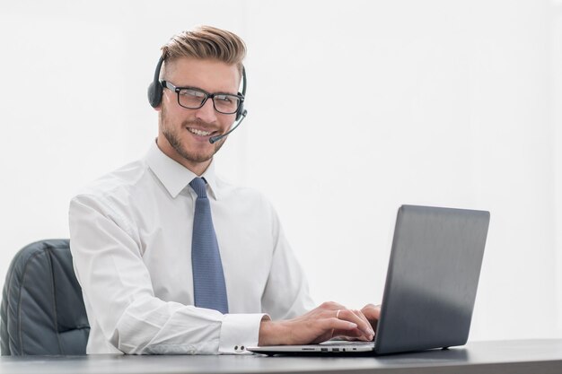 Smiling man in headphones working on a laptopphoto with copy space