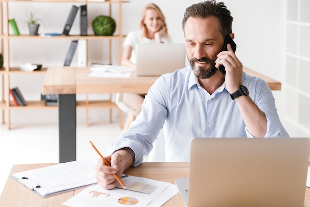 Smiling man manager working with laptop computer