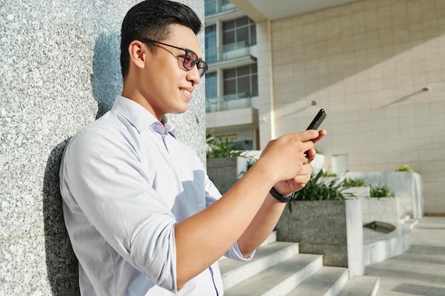 Smiling man reading text message