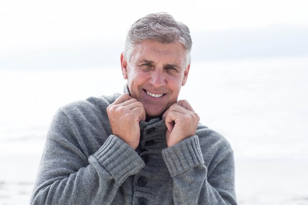 Smiling man standing in the sand