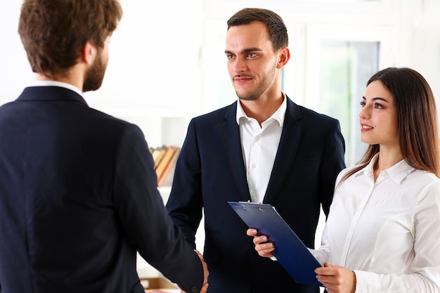 Photo smiling man in suit shake hands as hello in office