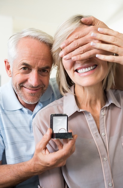 Smiling man surprising woman with a wedding ring