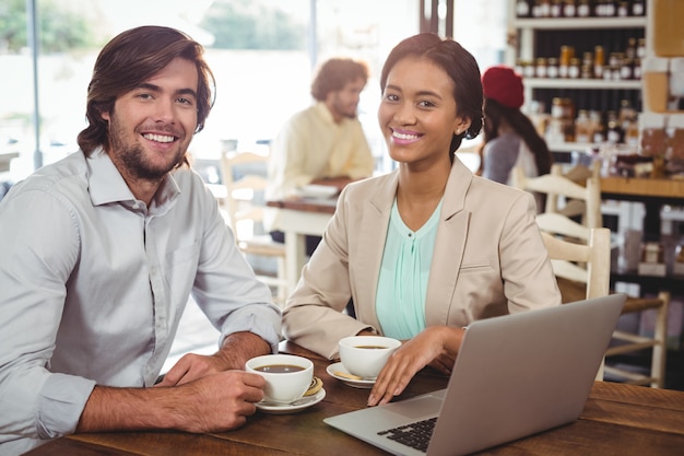 Smiling man and woman having cup of coffee