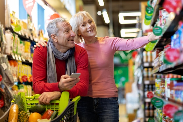 Smiling man and woman shopping at supermarket