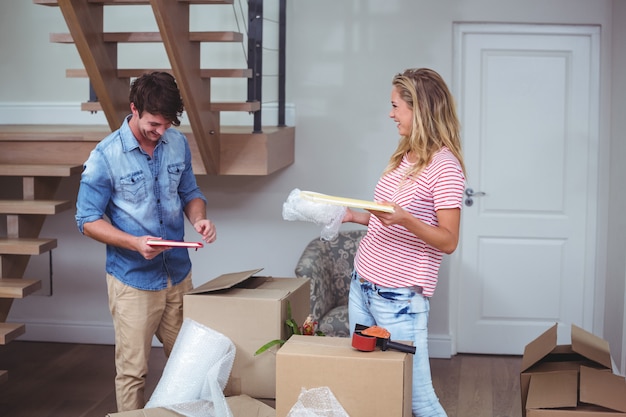 Smiling man and woman unpacking books 