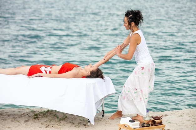 Smiling massage therapist doing a back massage on outdoor