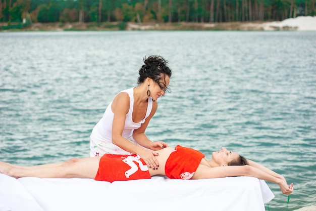 Smiling massage therapist doing a back massage on outdoor