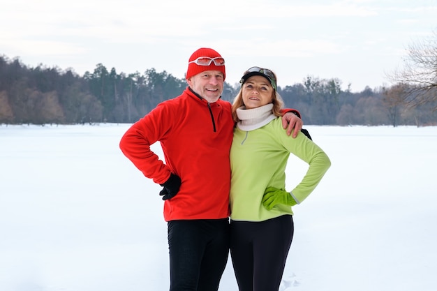 Smiling mature couple hugging in park in winter