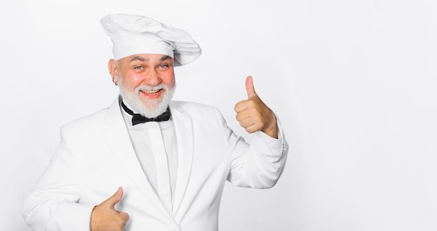 Smiling mature male chef showing thumbs up approve menu bearded cook in chef hat with perfect sign