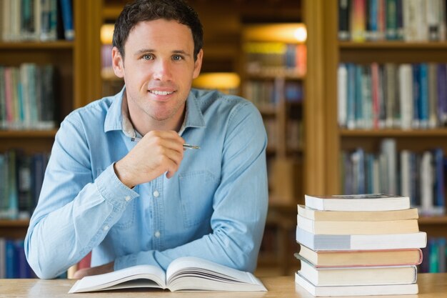 Smiling mature student studying at library desk