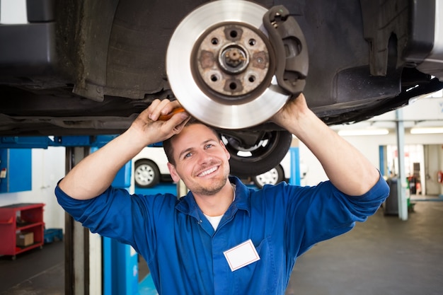 Smiling mechanic adjusting the wheel