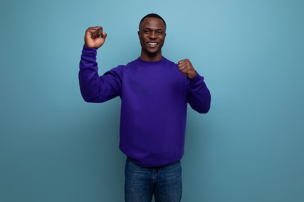 Smiling modest young man living in america on a blue background with copy space