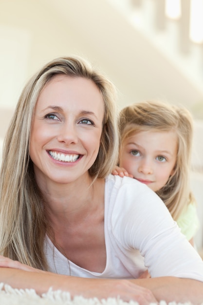 Smiling mother and daughter on the floor