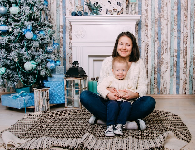 Smiling mother and son near Christmas tree