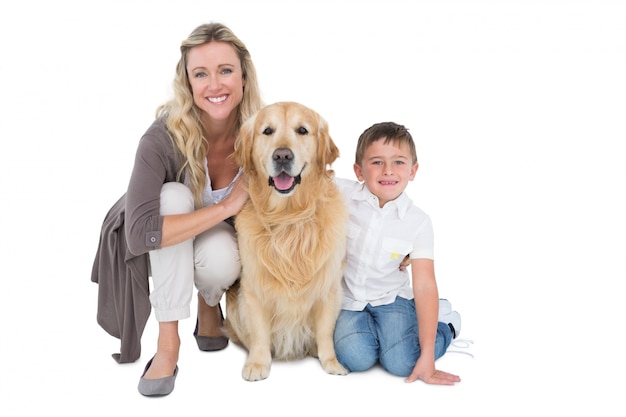 Smiling mother and son petting their golden retriever