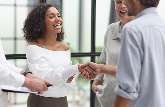 Smiling multiethnic businesspeople shaking hand in office